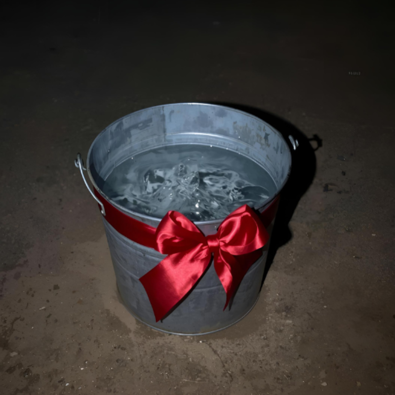 An image of a metal pail with water and a bow used to put sparklers after the wedding sparkler send off is done.