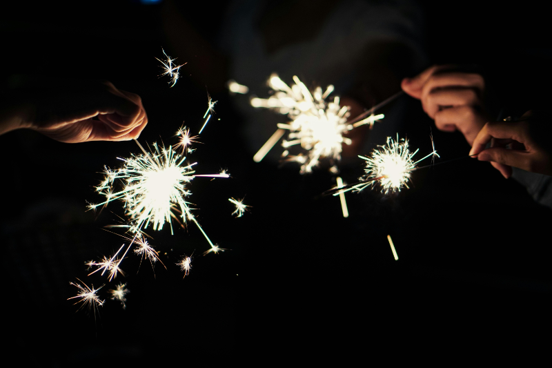 Image of adults holding lit sparklers.