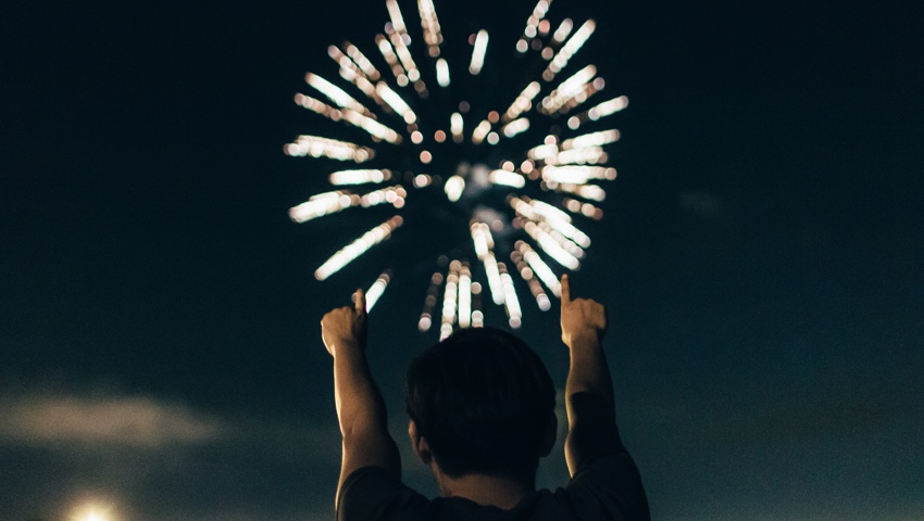 Man cheering to fireworks display