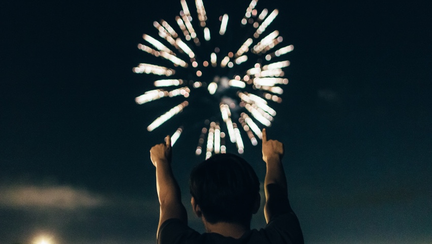Man cheering to fireworks display Man cheering to fireworks display